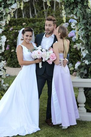 Lacey Mark, dressed in pink, stands on her tiptoes to kiss bachelor Nick Viall.
